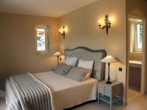 BoffresChâteau de Cachard的一间卧室配有一张大床、两盏灯和两张桌子