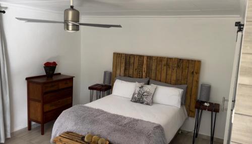 DalmadaPan's Breeze Overnight Accommodation的一间卧室配有一张带木制床头板的床