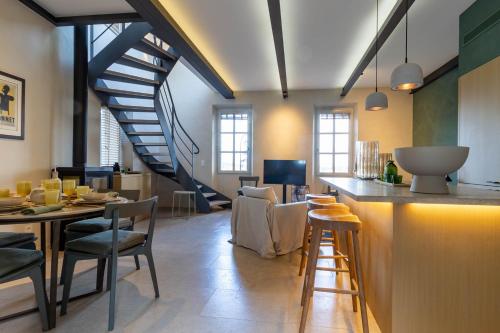 穆然Mougins Collection - Magnifique maison au Cœur du Vieux Village de Mougins, vue sur les Alpes du Sud的客厅设有楼梯和桌椅
