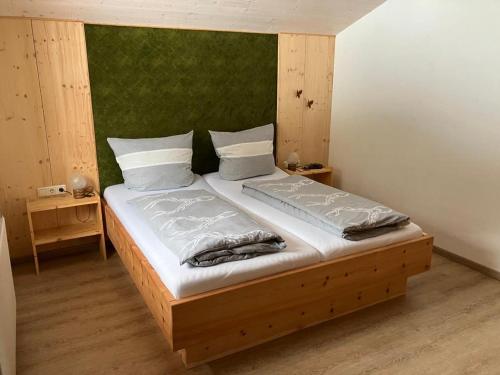 格伦Ferienwohnung Erika Masuck的一间卧室配有一张大床和绿色床头板