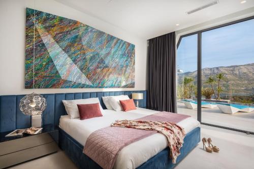 泽尔诺沃Luxury Villa Korcula Diamond的卧室配有一张床,墙上挂着一幅大画