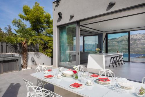 泽尔诺沃Luxury Villa Korcula Diamond的庭院内带桌椅的用餐室