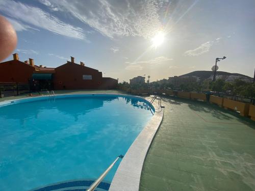 洛斯克里斯蒂亚诺斯Simon beach house Los Cristianos的一座阳光灿烂的天空大型游泳池