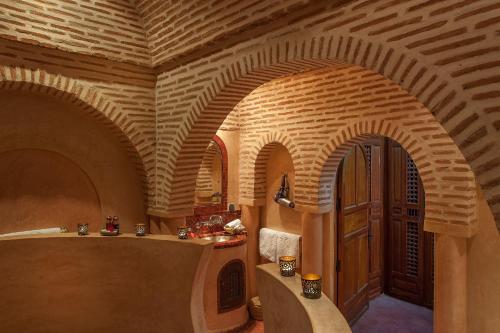 马拉喀什桑德斯摩洛哥传统庭院住宅的一间设有拱形天花板和木门的客房