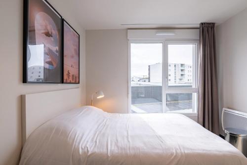 勒阿弗尔Student Factory Le Havre Les Docks的卧室配有白色的床和窗户。