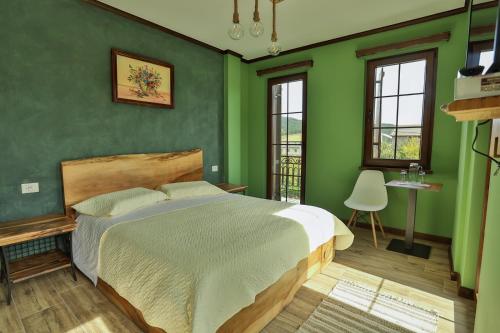 沃斯科波亚Vila Strugu的一间拥有绿色墙壁和一张大床的卧室