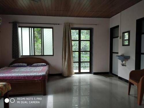 卡希德Suvarna Holiday Home的一间卧室设有一张床和两个窗户。