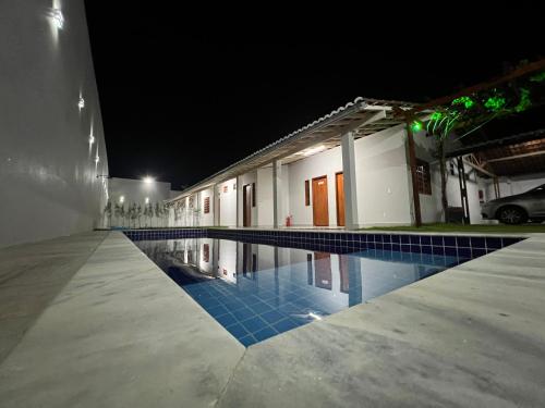 皮拉尼亚斯Pousada Pelo Sertão的一座游泳池,在晚上在建筑物前