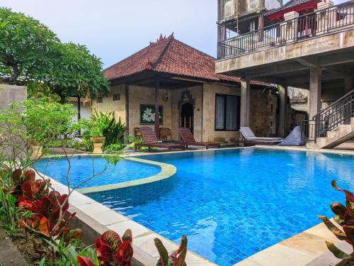 库塔Taman Sari Cottages的房屋前的游泳池