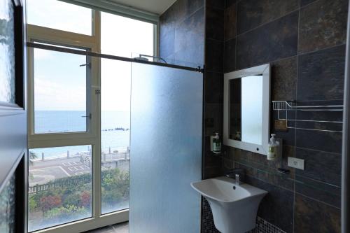 花莲市海传民宿 的一间带水槽和玻璃淋浴间的浴室