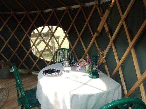 芬赫斯特'Oak' Yurt in West Sussex countryside的圆顶帐篷内的一张桌子,上面有白色的桌布