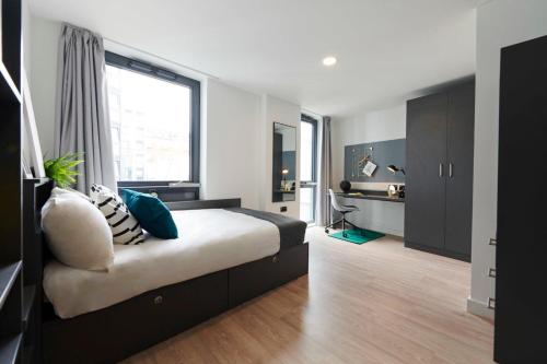 都柏林Chic Apartments and Private Bedrooms at Beckett House near Dublin City Centre的一间卧室设有一张床和一个大窗户