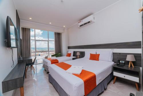 塔拉波托Palm Hotel Tarapoto的酒店客房设有两张床和电视。