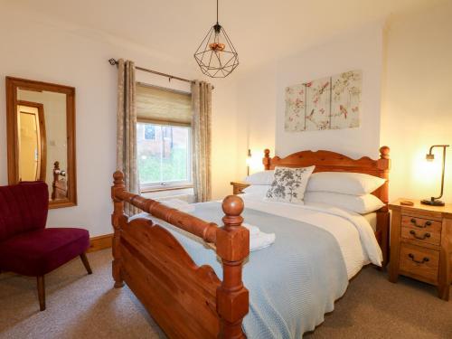 阿什伯恩Poppy Cottage的卧室配有床、椅子和窗户。