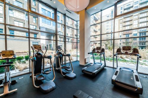 华沙可比克阁楼公寓式酒店的带有氧运动器材的健身房,位于带窗户的建筑内