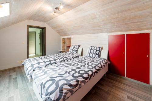 Les WaleffesLe Boca的一间卧室设有两张床和红色橱柜