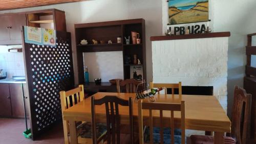 拉帕洛马Casa en Barrio Country - La Paloma的一间带木桌和椅子的用餐室