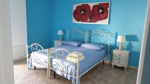 斯佩基亚美景如画住宿加早餐旅馆的蓝色卧室,墙上挂着红色鲜花