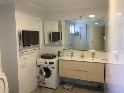 珀斯Parkline Apartments Perth的一间带洗衣机和水槽的浴室