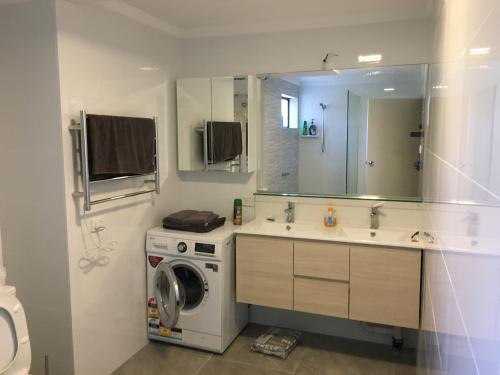 珀斯Parkline Apartments Perth的一间带洗衣机和水槽的浴室