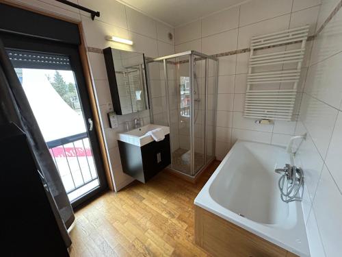 弗朗科尔尚拉斯客房旅馆的带浴缸、水槽和淋浴的浴室