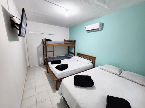 马利西亚斯Cantinho residencial的小房间设有两张床和一张书桌