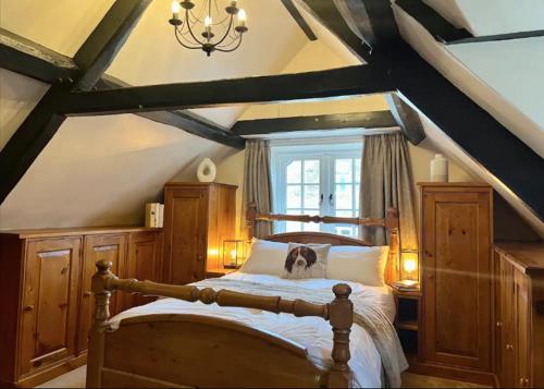 查尔伯里China Cottage - Quaint, Cosy, Cotswolds Retreat的一间卧室配有一张带木制家具的大床