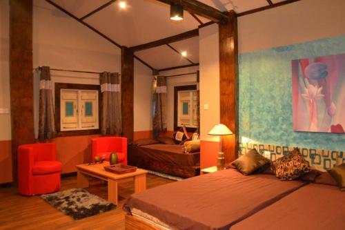 帕西库达Cocoville的一间卧室配有一张床、一张沙发和一张桌子