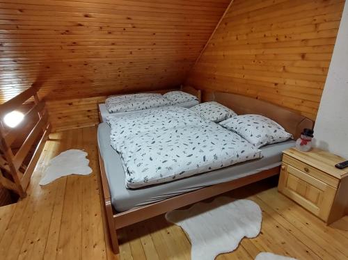 OplotnicaBrunarica 6A - Smučišče Trije Kralji的木质客房的一张床位,铺有木地板