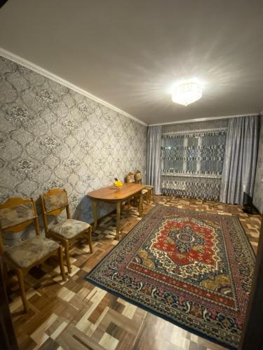 科克舍套Сдам квартиры посуточно的一间带桌椅和地毯的用餐室