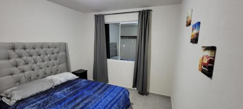 HuejotzingoDepartamento Aeropuerto Puebla的一间卧室设有一张床和一个大窗户