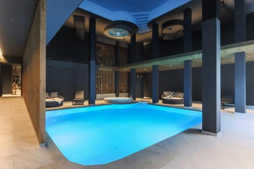 纳兹-夏韦斯Hotel Waldheim的蓝色灯光建筑中的一个大型游泳池