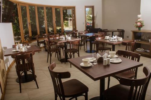 普孔Cocurantu Hotel Boutique的餐厅设有木桌、椅子和窗户。