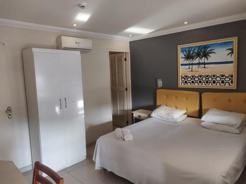 皮拉伊河畔巴拉Lemes Hotel的卧室配有白色的床和墙上的绘画作品