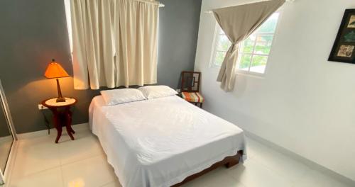 圣斐利-银港Cozy 2BR Near Playa Dorada, 3 Min In Car的卧室配有白色的床和窗户。