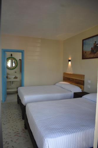 科苏梅尔LUNA AZUL BY UVAS的酒店客房设有三张床和一间浴室。