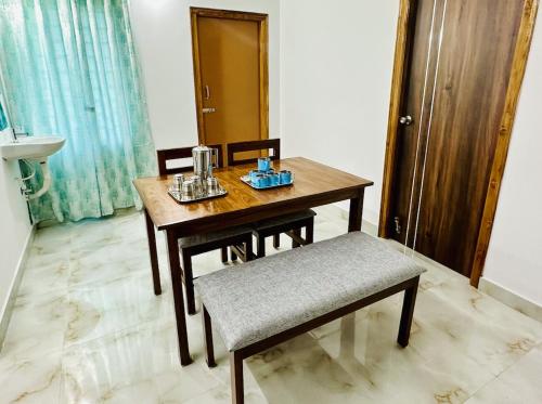 蒂鲁帕蒂Tirupati Homestay - Shilparamam - Luxury AC apartments by Stayflexi - Fast WiFi, Kitchen, Android TV - Walk to PS4 Pure Veg Restaurant - Easy access to Airport, Railway Station and to all Temples的木桌和椅子