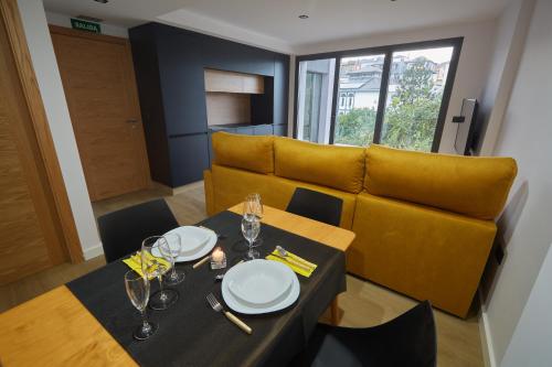 韦加港HAVANAAPARTAMENTOS的一间带桌子和黄色沙发的用餐室