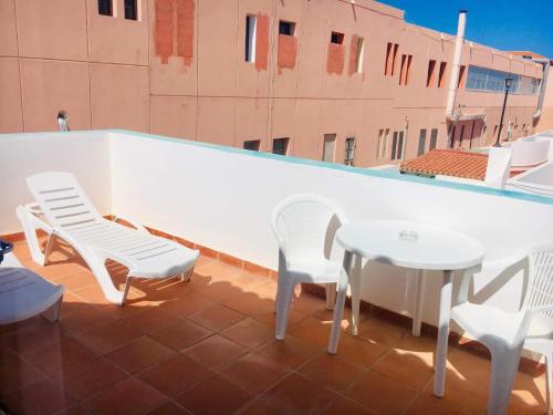 卡勒达德福斯特卡斯塔富尔特酒店的屋顶上配有白色椅子和桌子的庭院