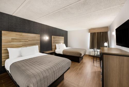 韦恩Essence Express Wayne的酒店客房设有两张床和一台平面电视。
