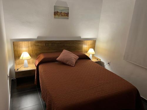 派桑杜Apart del Este 4的一间卧室,两边都配有一张床和两盏灯