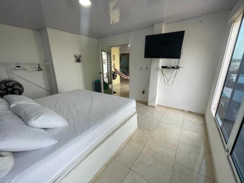 San OnofreLuna Roja casa Frente al Mar y glamping的卧室配有白色的床和平面电视。