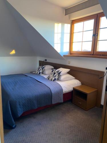 涅波伦特HOTEL CICHA WODA NIEPORĘT的一间卧室配有一张带蓝色毯子的床