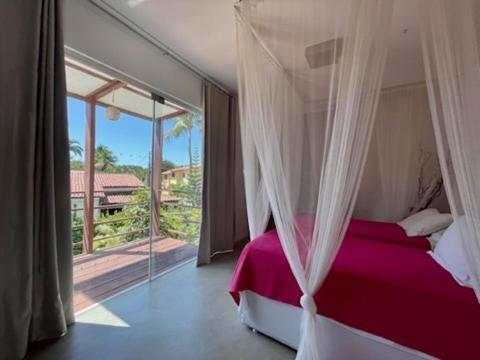 皮帕La Réserve Design Villas的一间卧室设有一张天蓬床和大窗户