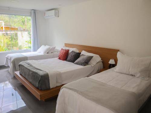 Saco do CeuPousada Gata Russa的一间卧室设有两张床和窗户。