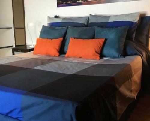 巴勒莫House Busacca di Gallidoro的一张大床,上面有橙色和蓝色的枕头