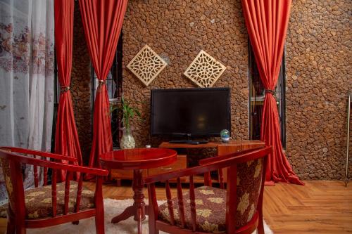 坎帕拉Green Villa Apartments的客厅配有红色窗帘和电视