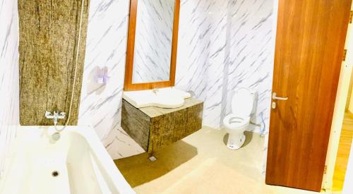 PuunggolakaThe Bonte Hotel的浴室配有盥洗盆、镜子和浴缸