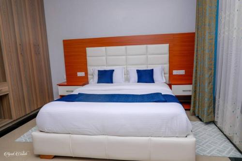 MeruLuxe Furnished Premium Unit的卧室配有带蓝色枕头的大型白色床
