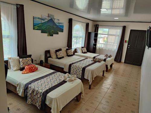 利比里亚HOTEL DEL RiO的一间酒店客房,房间内设有四张床